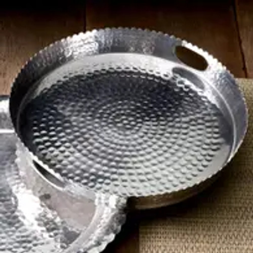 The Hammered Round Handle Tray is a versatile and stylish addition to any home. Crafted from durable aluminum, this tray features a stunning silver hammered finish that adds a touch of elegance to any setting. With its round shape and convenient handle, it is perfect for serving drinks, appetizers, or desserts at your next gathering. The sturdy construction ensures that this tray will withstand the test of time, making it a great investment for both everyday use and special occasions. Whether you are hosting a dinner party or simply enjoying a quiet evening at home, the Hammered Round Handle Tray is sure to impress your guests and elevate your serving experience. It also makes for a thoughtful and practical gift for housewarmings, weddings, or any other special occasion. Upgrade your serverware collection with this exquisite tray and add a touch of sophistication to your home.