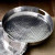 The Hammered Round Handle Tray is a versatile and stylish addition to any home. Crafted from durable aluminum, this tray features a stunning silver hammered finish that adds a touch of elegance to any setting. With its round shape and convenient handle, it is perfect for serving drinks, appetizers, or desserts at your next gathering. The sturdy construction ensures that this tray will withstand the test of time, making it a great investment for both everyday use and special occasions. Whether you are hosting a dinner party or simply enjoying a quiet evening at home, the Hammered Round Handle Tray is sure to impress your guests and elevate your serving experience. It also makes for a thoughtful and practical gift for housewarmings, weddings, or any other special occasion. Upgrade your serverware collection with this exquisite tray and add a touch of sophistication to your home.