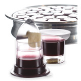 Simply Communion prefilled communion cup with Concord grape juice and bread, shown with lid partially peeled and tray of sealed cups behind