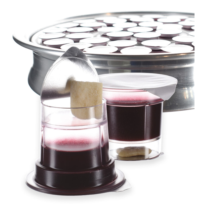 Simply prefilled communion cups with Concord grape juice and gluten-free bread beside silver tray
