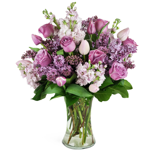 Cool Toned & Collected is a soft and elegant arrangement in lavender and light pink featuring roses, tulips, lilac, and garden stock. A calming bouquet with spring charm.