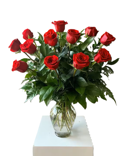 The most universally loved flower in a classic presentation. A dozen long-stemmed roses are accented with vibrant seasonal foliage in an elegant glass vase.