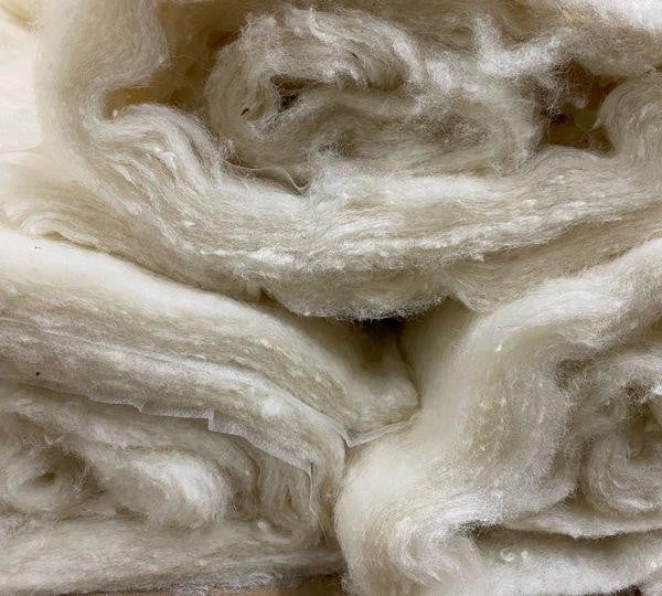 Organic Wool Batting, close-up of soft, fluffy, natural white wool fibers ideal for quilting and crafting.
