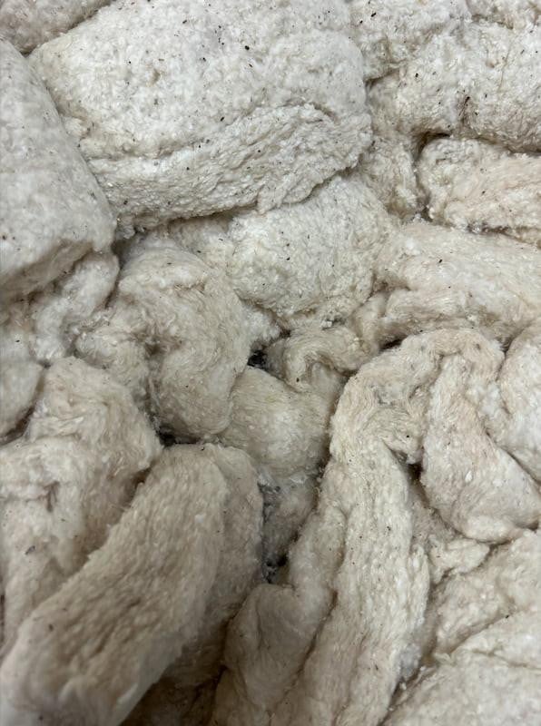 Scrap Cotton Batting, close-up of shredded, soft, and fluffy cotton batting material for quilting and insulation.