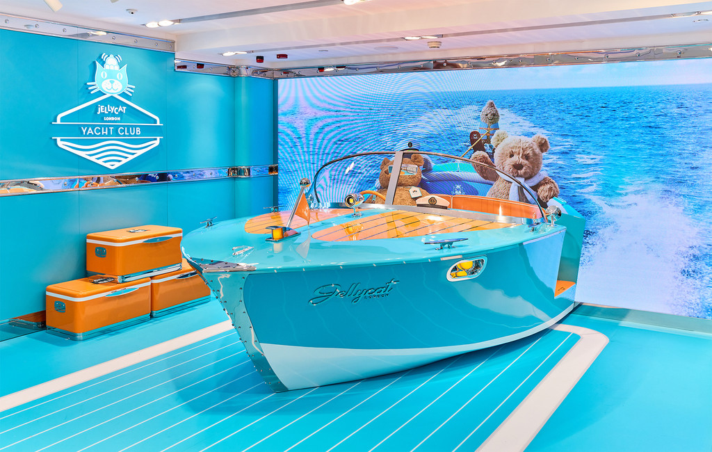 Bartholomew Bear sits aboard a turquoise speedboat inside the Jellycat Yacht Club experience.