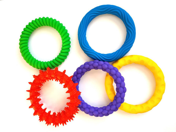 Colorful rubber dog rings, a set of various textured rubber chew toys for dogs in green, blue, red, purple, and yellow.