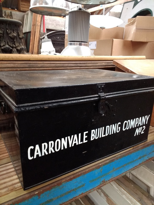 A large black vintage metal box with side carrying handles.  Lettering on the front in white : Caronvale Bulding Company No2.   A large black vintage metal box with side carrying handles.  Lettering on the front in white : Caronvale Bulding Company No2.