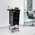 Kobe Design Salon Trolley, black mobile salon cart with multiple storage shelves and tools on top in a modern salon setting.