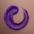 Kaeso Hand Care Cranberry Hand Scrub, close-up of the purple textured scrub in a spiral shape on a beige surface.
