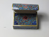 A unique and ornate hand-painted ring box, serving as a beautiful cultural accessory for wedding ceremonies and proposals.