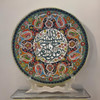 A premium 25 cm handmade clay plate featuring embossed Islamic calligraphy surrounded by a vibrant, multi-colored floral mosaic for wall decor.