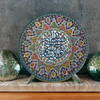 A premium 25 cm handmade clay plate featuring intricate Islamic calligraphy surrounded by a vibrant, multi-colored floral mosaic for wall decor.