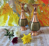 metallic reflection of the hand-spun copper necks and the balanced geometric contours of the 20 cm paired artisan flower vases.