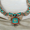 A stunning handcrafted necklace with turquoise, red coral, and green stone beads, perfect for adding a bohemian touch to any outfit.