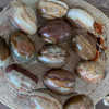 A collection of hand-polished natural onyx decorative eggs in a basket, making a perfect unique gift.