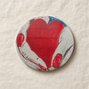 A professionally presented 9 cm round printed ceramic coaster featuring an artistic illustration of hands with red manicured fingernails holding a vibrant red heart against a dark blue fabric background.