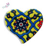 A heart-shaped printed ceramic fridge magnet featuring a vibrant yellow, blue, orange, and red geometric mosaic tile pattern with a central floral medallion.