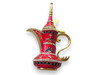 A detailed view of the high-pointed finial and handle of the red enamel Dallah, showcasing the smooth, glossy finish.