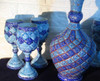 Close-up view of intricate floral and geometric Minakari enamel work on a handcrafted copper decanter and drinking goblet.