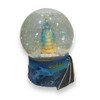 A professional product shot of the dolphin and landmark snow globe displayed on a clean surface.