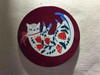 A detailed close-up highlighting the charming folk-style sleeping cat illustration, red botanical patterns, and smooth glazed ceramic finish of the coasters.