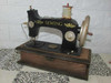 Close-up of the metal hand wheel and needle mechanism on the decorative vintage sewing machine sculpture.