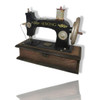 A handcrafted metal model of a vintage sewing machine with a black body and silver accents on a wooden base.