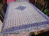 A dining table styled with a Ghalamkar tablecloth, ceramic plates, and candles, highlighting its use for elegant Persian-style hosting.