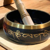 The Tibetan singing bowl shown as a sophisticated sound therapy tool in a modern luxury yoga and meditation space.