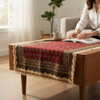 A detailed close-up highlighting the soft cotton weave, rich red tones, fine hand-printed patterns, and traditional fringe of the Ghalamkari table cloth.
