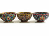 A detailed close-up highlighting the tactile embossed surface, raised floral and paisley patterns, and richly layered enamel colors on natural clay.