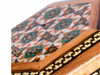 Close-up of the meticulous brass, bone, and wood triangle inlaying technique on the 5x5 cm Persian jewelry box.