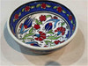 A premium 12 cm handmade Turkish ceramic bowl featuring vibrant red tulip patterns and a high-gloss food-safe glaze.