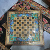 Close-up of the hand-painted Tazhib floral motifs and gold-toned accents on the interior backgammon field.