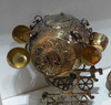 Studio view of the antique-style brass barrel dispenser featuring detailed floral hand-carvings and hanging brass cups.