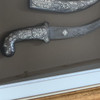 etailed close-up of the artisanal hand-engraving on the ceremonial weapon scabbard, highlighting the fine symmetrical leaf motifs, dark contrasting backgrounds, and polished silver vine patterns.