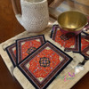 Elegant fabric coasters with intricate floral carpet motifs, perfect for protecting dining surfaces.