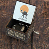 A professional product shot of the vintage-style wooden music box with an open lid revealing detailed camel artwork and the Abu Dhabi theme.
