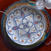 A 30 cm Moroccan plate featuring hand-painted ceramic artwork with traditional blue, orange, and white patterns.