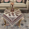 A vibrant 100x100 cm artisan cotton table cloth and tapestry featuring traditional Persian Ghalamkari paisley motifs, decorative fringe, and rich indigo and rust tones.