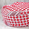 A professional product shot of the traditional red and white shemagh styled neatly against a neutral background.