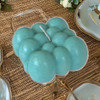 A professional product presentation of the exclusive teal blue bubble candle from a premier UAE gift shop.