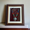 Adorable Nepali multi-strand beaded necklace with a central metal pendant, elegantly framed as wall decor.
