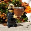 A traditional Omani woman figurine incense burner wearing a black abaya and holding a decorated mabkhara bowl outdoors.