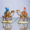 The "Caravan Duo" camel rider figures shown as a prestigious decorative accessory on a modern luxury bookshelf in Dubai.