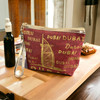 Decorative 20x16 cm printed pouch with a wrist strap, perfect for travel keepsakes.