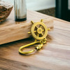 A sturdy brass keychain with a classic ship wheel emblem and a convenient screw-closure hook.