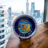 A professional product presentation of the 15 cm blue and gold Qatar decorative plate in an urban setting.