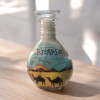 Close-up of the 15 cm sand bottle showing a personalized name written in natural colored desert sand.