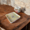 A view of the mug and tray set showcasing the unique, shimmering iridescent finish and artisanal craftsmanship.